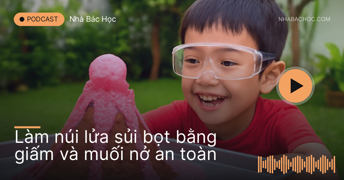 Ngọn núi đất nặn trên khay sủi bọt hồng, bé đeo kính bảo hộ đứng xem